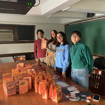 Four students make goodie bags for fall holiday