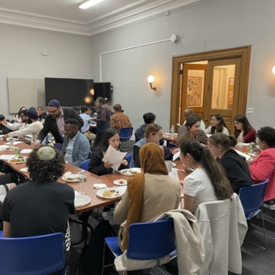Students and religious leaders eating and learning together during the multi-faith fellowship.