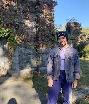 Lucas stands next to an ivy-covered stone building