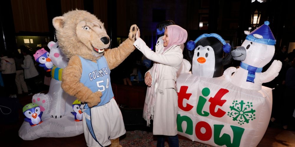 Student high fives Roar-ee