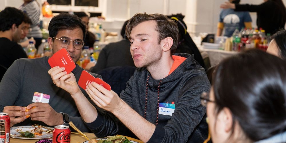 Students Play cards at Dinner with Strangers