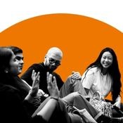 Black and white image of four students in conversation. Orange Background.