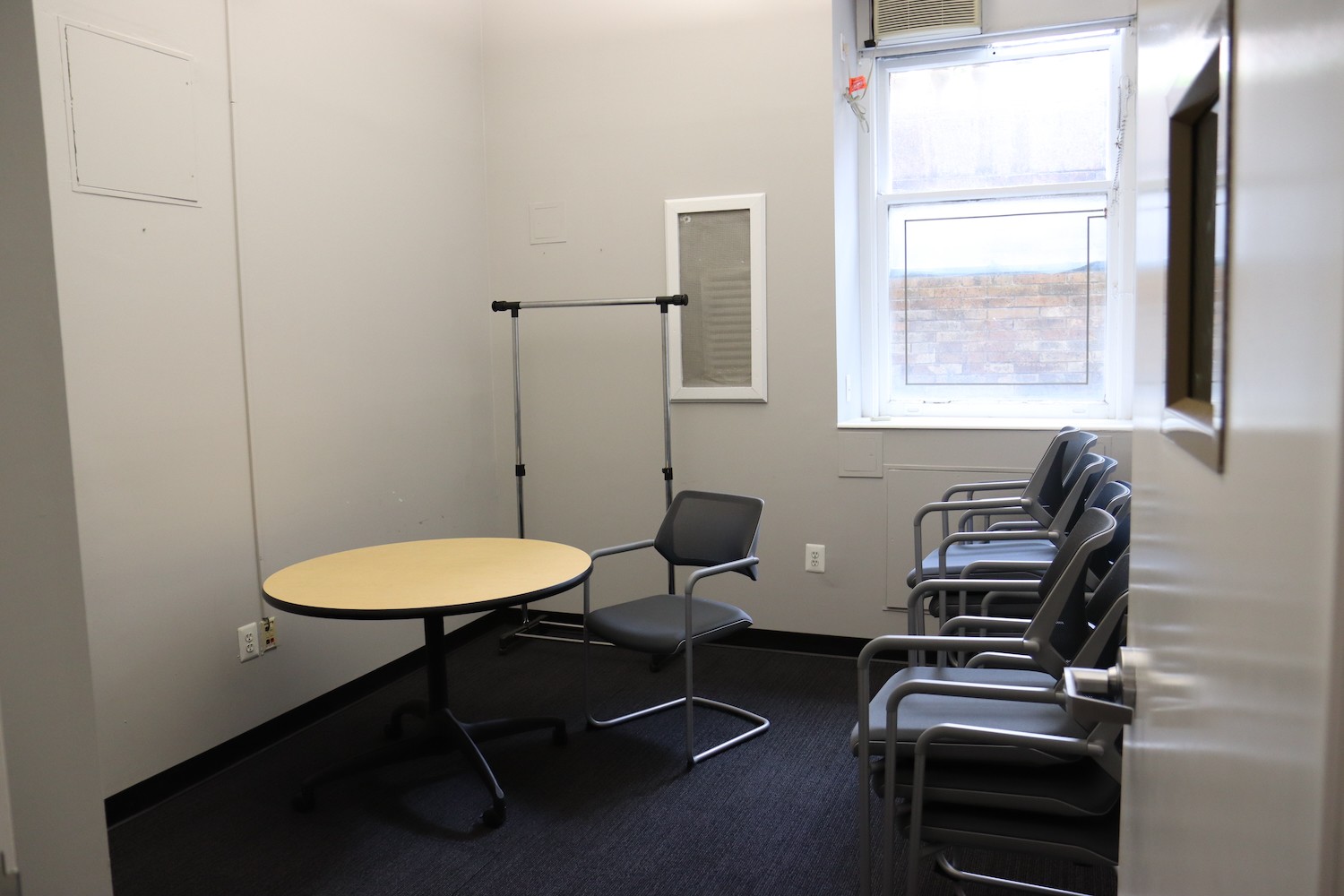 A small room with a round table and a few chairs