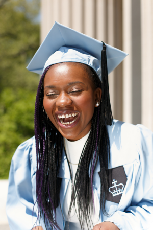 Tenneh smiling in graduation cap and gown