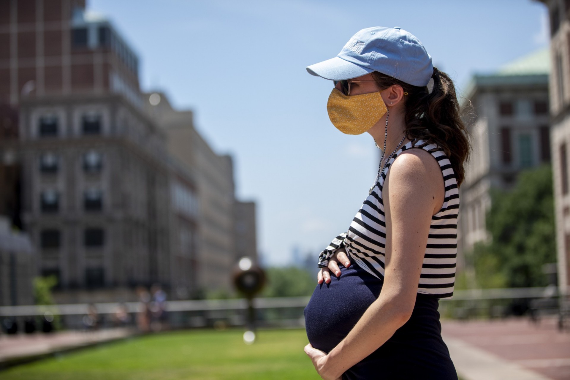 A pregnant person stands on Columbia's campus