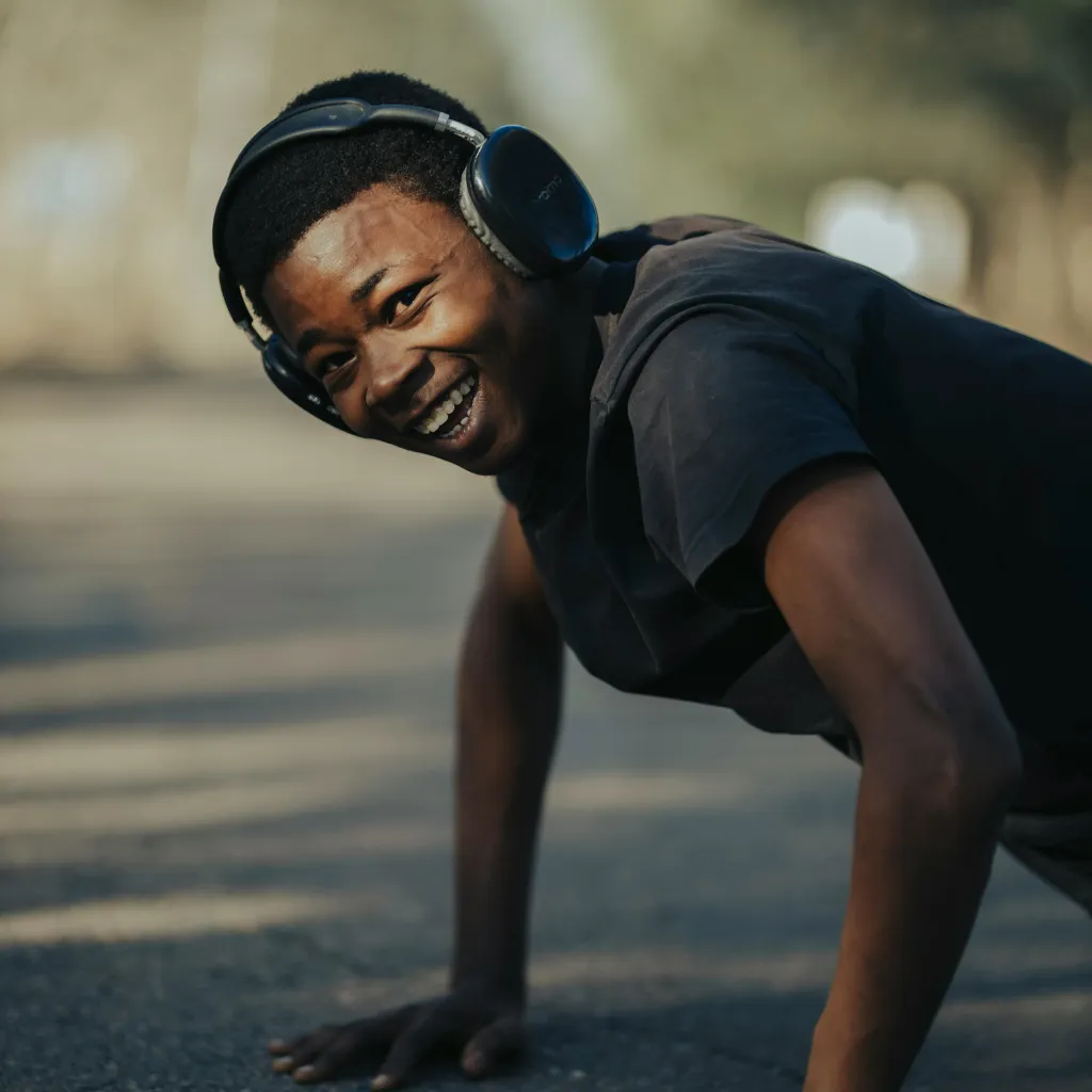 A man does push-ups while smiling 