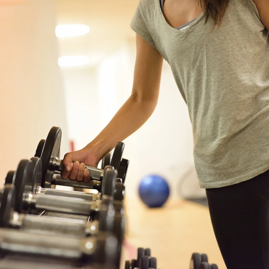 Person lifting a weight from a rack