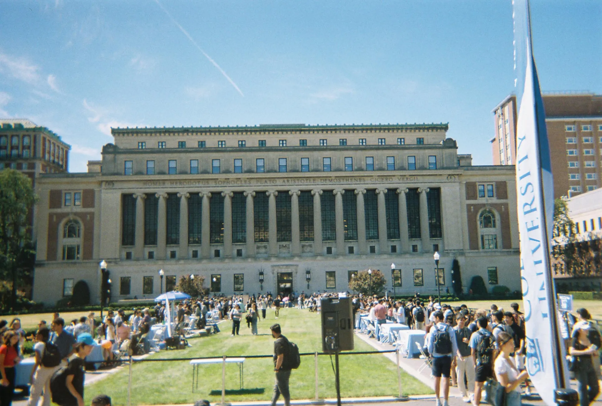 A picture of the outside of Butler Library with groups of people talking and walking