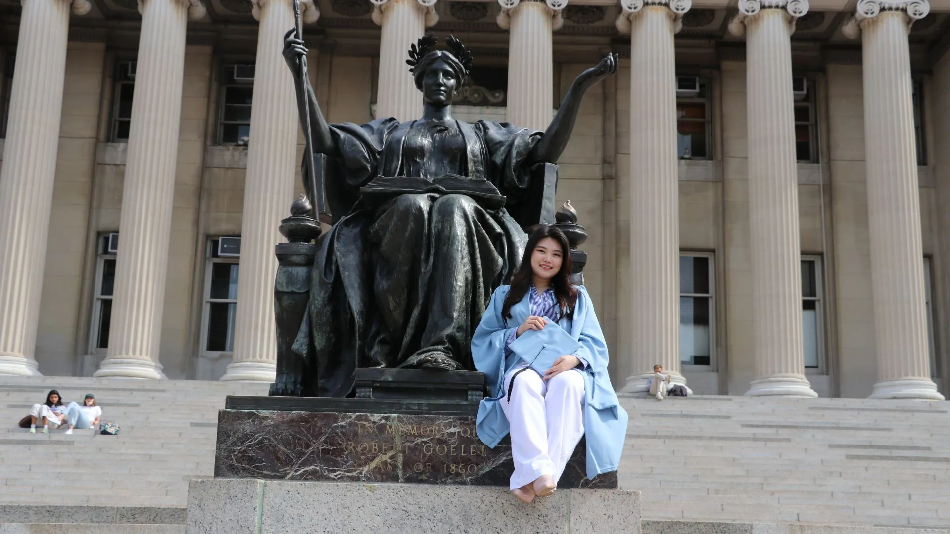 D.J. sits with Alma Mater in cap gown